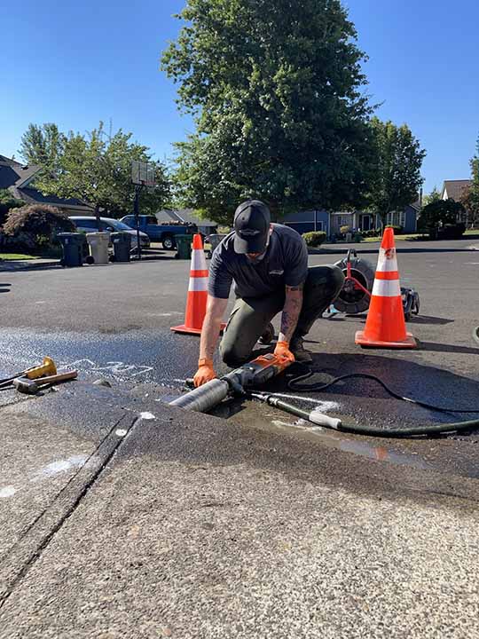 worker cleaning out drain