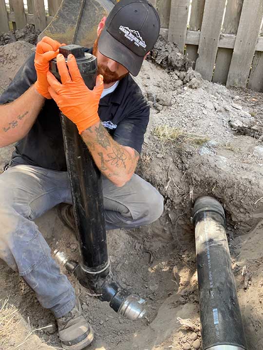 Cascade Building Services worker fixing drain